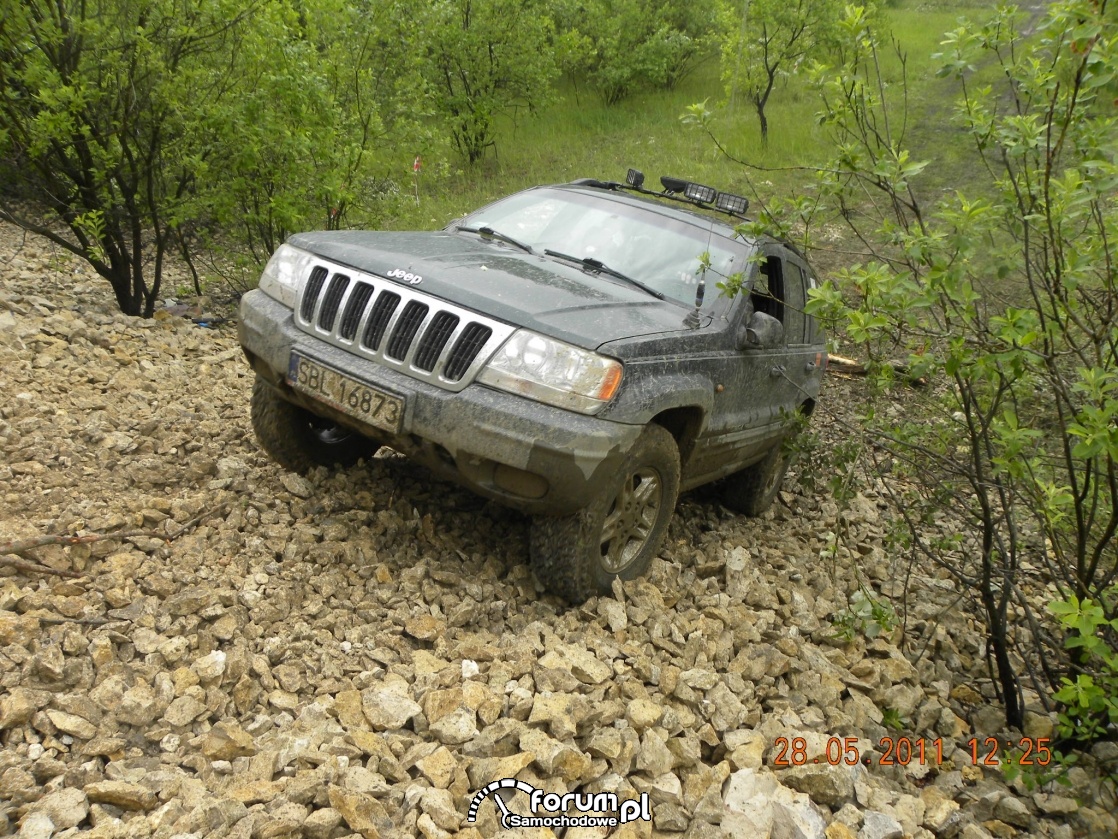 Jeep Grand Cherokee wjeżdża po stromym kamienistym zboczu